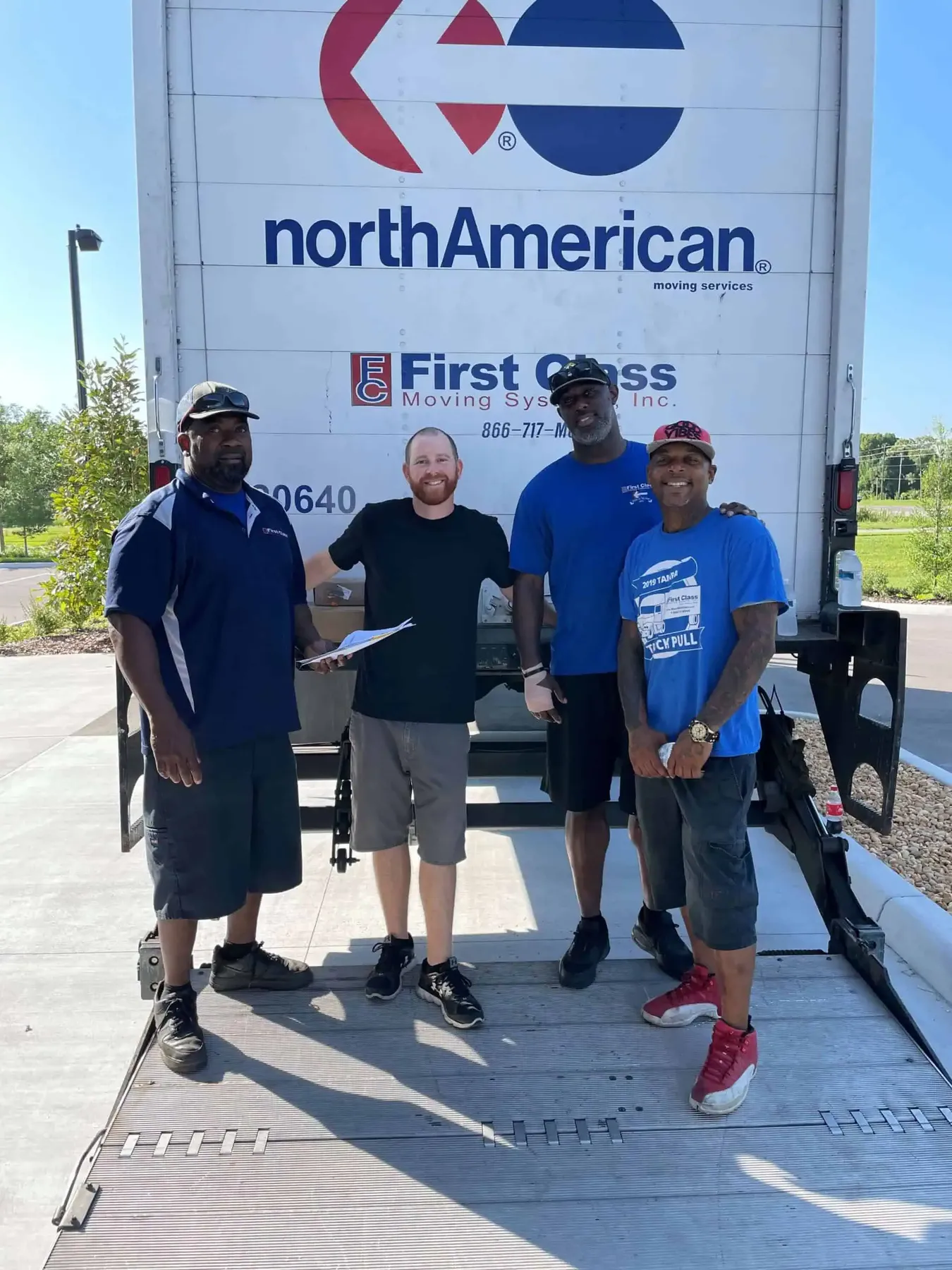 Moving crew standing at the back of a North American trailer