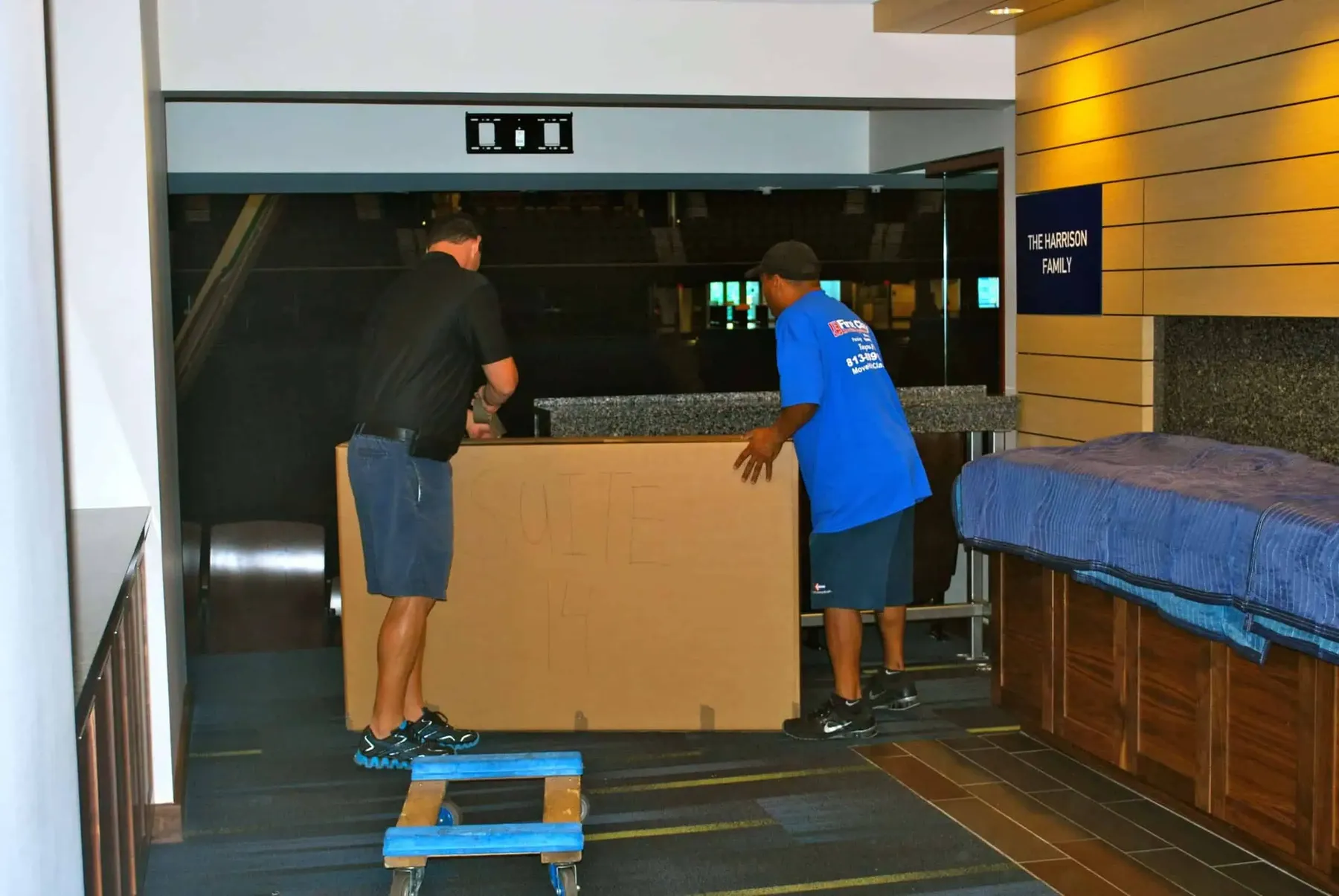 Movers handling a large crate in a venue
