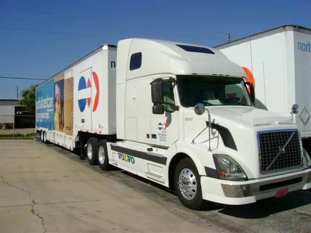 White Volvo tractor pulling a North American Van Lines trailer